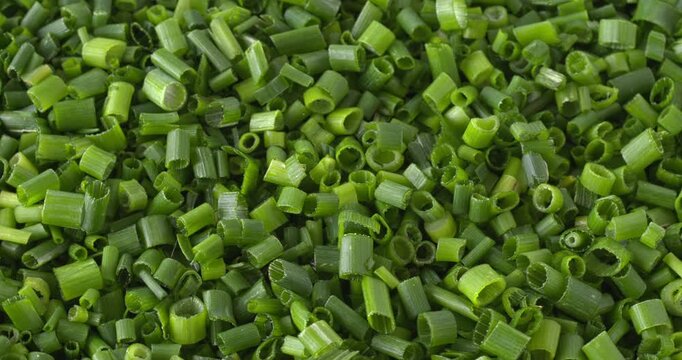 Thinly chopped fresh chives from your own garden as background texture. Close-up, table spin, natural light, 4K DCI. 