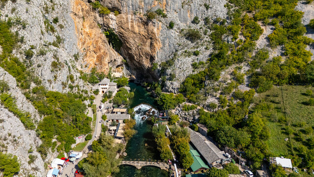 Aerial view of the historic Blagaj Tekke monastery nestled at the base of a massive limestone cliff beside the turquoise Buna river in Blagaj, Federation of Bosnia, Bosnia and Herzegovina.