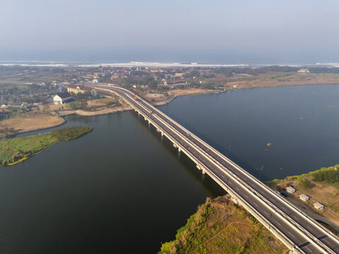 Aerial view of the Kretek bridgespanning the Opak River with surrounding coastal landscape and vegetation in Kecamatan Kretek, Daerah Istimewa Yogya, Indonesia.