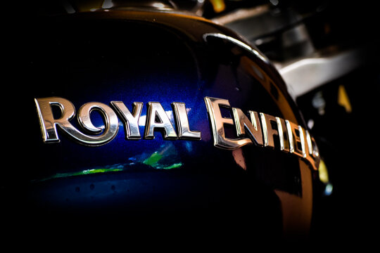 KERALA, INDIA - JULY 20, 2020: Close up of chrome Royal Enfield logo emblem on blue metallic fuel tank with selective focus.
