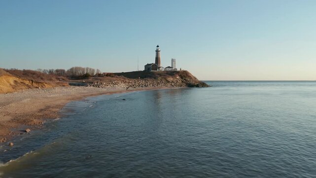 Scenic view of a lighthouse on a rocky shore at sunset