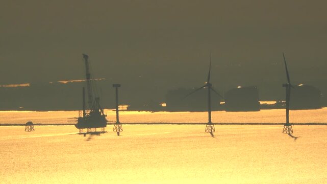 石狩湾新港沖の船体をジャッキアップした洋上風力発電の設置作業と石狩湾の朝