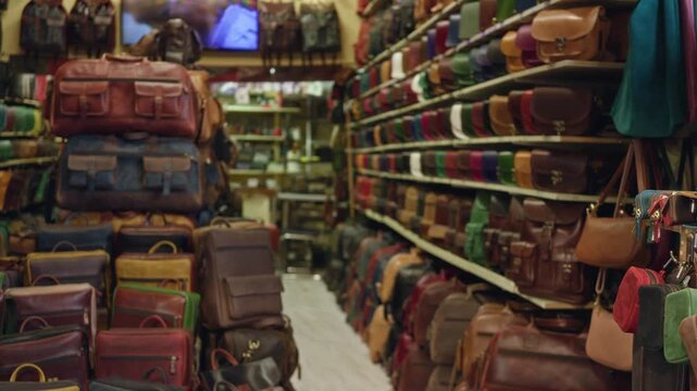 Blurred leather bag shop interior with shallow bokeh aisle, stacked shelves and soft defocused retail backdrop; background backplate copyspace.