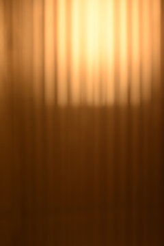 A dreamy view of a golden yellow light on the wall.