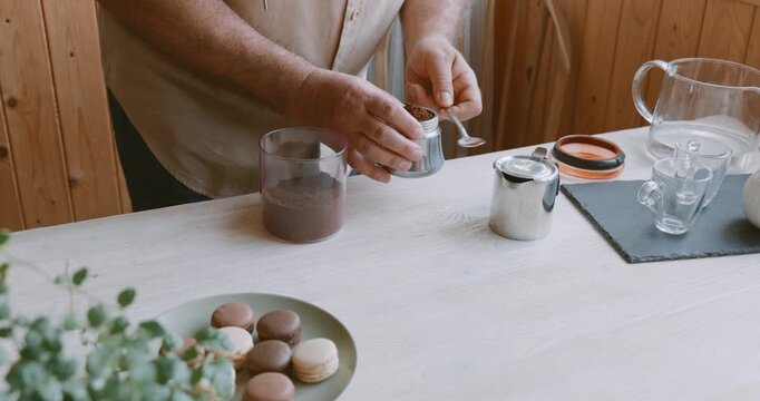 Man making coffee at home, putting ground coffee into moka pot. Preparation home coffee, morning ritual, coffee brewing process.