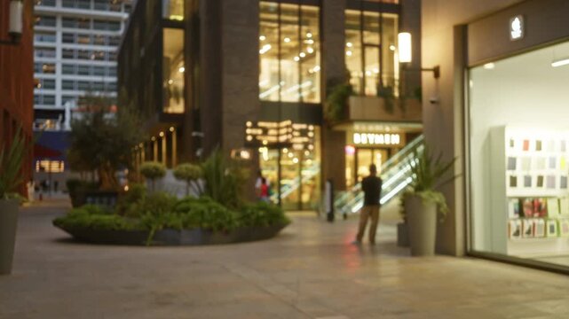Blurred shopping center bokeh background shop with soft warm lights and out of focus storefronts; background copyspace calm.