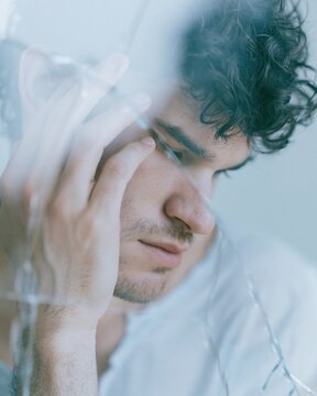 one fictional male portrait seen through a cracked transparent screen, parts of the reflection slightly misaligned