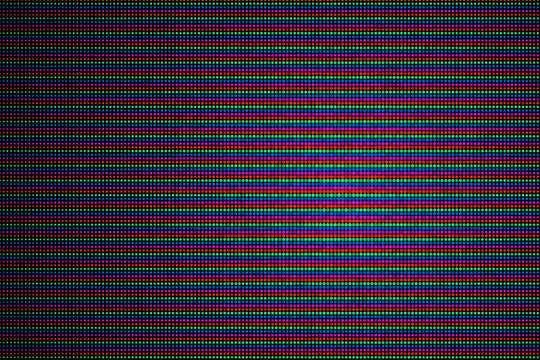Macro close up view of an electronic LED screen display showing red green and blue subpixel light emitting diodes 