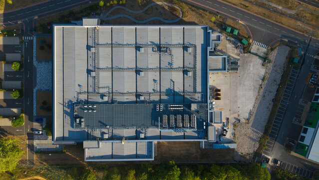 Aerial view of the Harwell Science and Innovation Campus, featuring a large industrial building roof with HVAC cooling units in Didcot, England, United Kingdom.