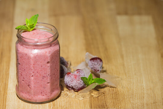 Fresh strawberry smoothie jar with frozen berries and mint copy space