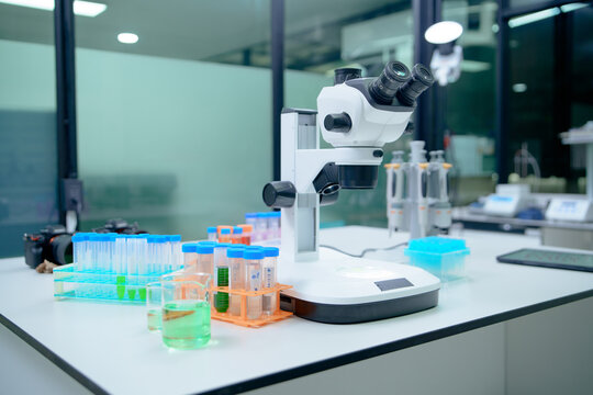 Laboratory Microscope Setup with Test Tubes and Chemical Solutions