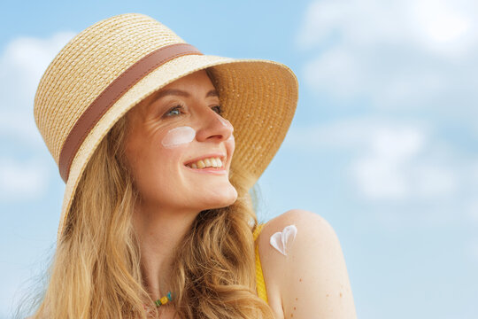 Woman Enjoying Sun With SPF Face Cream And Protective Hat