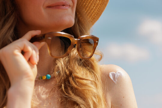 Sunscreen Heart on Woman Shoulder with Sunglasses at Sunny Beach