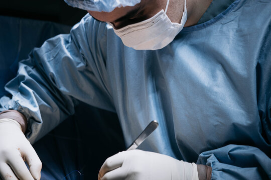 Close-up of a surgeon&rsquo;s gloved hands using surgical instruments during an operation, highlighting precise manual technique, sterile practice and detailed work in a hospital operating room.