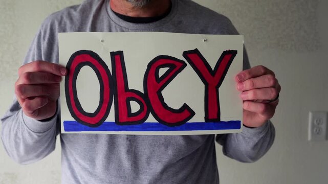 Man attaching protest license plates to vehicle using screwdriver, illustrating citizen pushback against ALPR surveillance - Fourth Amendment privacy