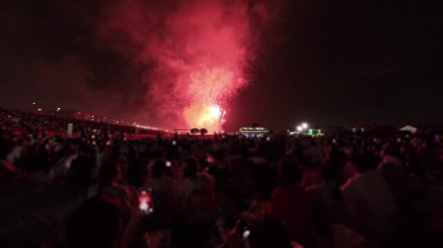 TOKYO, JAPAN - 28 JULY 2026 : Rear view of people silhouette watching fireworks show at night. Japanese romantic summer scene concept video.