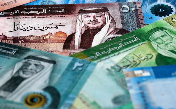 Jordanian dinar money bills pile on table. Jordan banknotes of JOD currency close up.
