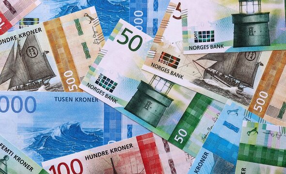 Norwegian krone money bills pile on table. Norway banknotes of NOK currency close up.