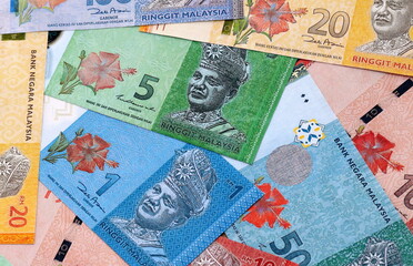 Malaysian ringgit money bills pile on table. Malaysia banknotes of MYR currency close up. © Larysa