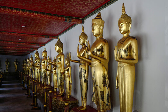 Row of golden Buddha statues inside Wat Pho temple in Bangkok Thailand