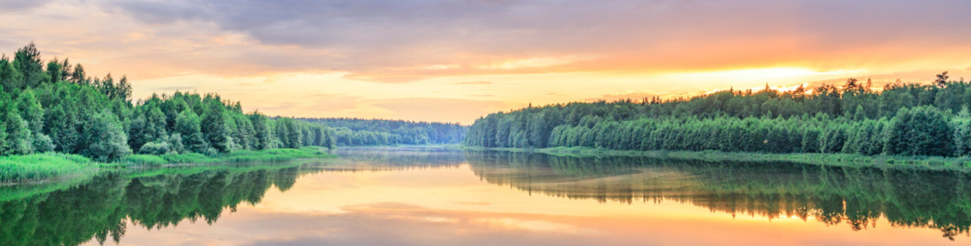 Golden sunset paints calm river's surface