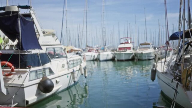 Marina scene with blurred boats, defocused masts and soft bokeh water background outdoor; background backplate copyspace calm.