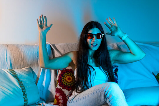 Woman protecting eyes from blue light at home, wearing specialized therapy goggles
