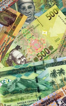 Guinean franc money bills in pile on table. Guinea GNF currency cash close up