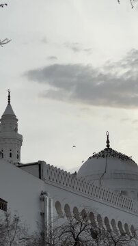 Cloudy view revealing the white dome and minaret of historic Masjid Al Qiblatain in Medina.