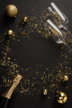 Happy New Year 2027 celebration with champagne, gold confetti and ornament on dark vertical background