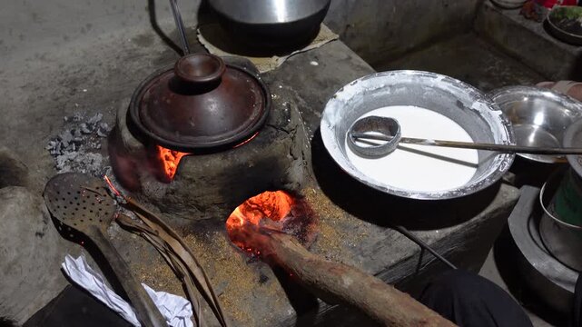 Chitai pitha is being made in a terracotta mold for making pitha in a heated clay oven. Chitai pitha is being made in a five-hole terracotta mold.