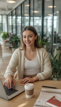 Smiling Young Woman Working on Laptop in Modern Office