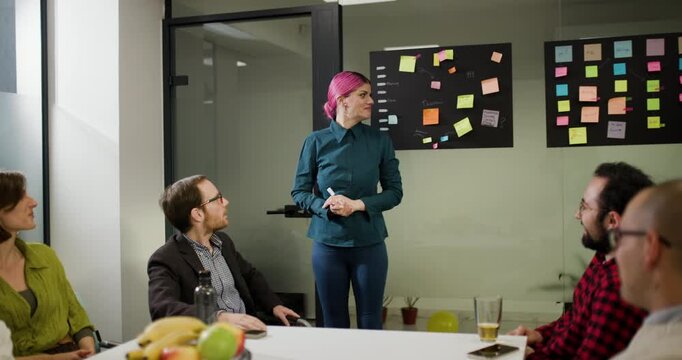 Team meeting focuses on project updates with business professionals discussing plans and ideas in a modern office environment during the afternoon