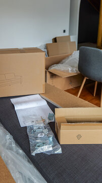 Unpacking flat-pack furniture boxes and assembly instructions for a new sofa