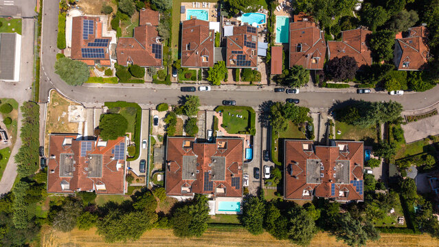Aerial View of a Residential Street: An overhead drone perspective reveals a charming suburban street lined with red-tiled roof houses, Bellaria, Peschiera Borromeo, Italy
