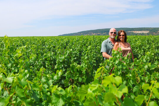 Couple enjoying Burgundy vineyard views, embracing summer travel, wine country charm, and peaceful rural landscape beauty.