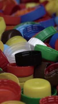 Close-up of multicolored bottle lids and caps forming a bright abstract texture ideal for eco campaigns, circular economy and anti-pollution content.