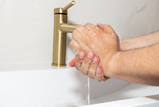 Close-Up of Washing Hands with Soap Under Running Water for Proper Hand Hygiene.