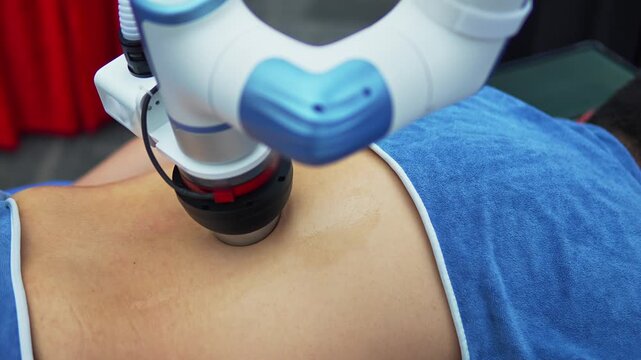 Closeup of a man lying down and receiving robotic back massage. Advanced AI powered device uses rollers and electric stimulation to ease pain and promote relaxation. High tech precision for body care.