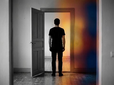 Person standing in a doorway split between grayscale and color
