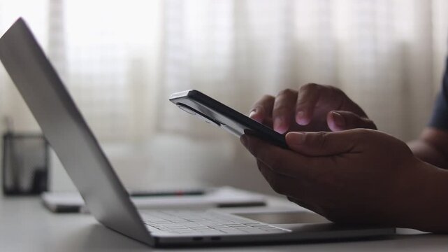 Close-up of man's hand using smartphone, scrolling, mobile phone, person typing phone, Businessman working on application, typing message, chatting, banking or swiping browsing online on smartphone.