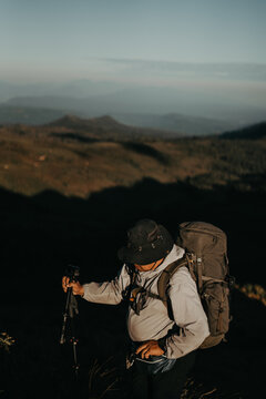 Backpacker Hiking on Mountain Ridge at Sunrise with Scenic Landscape