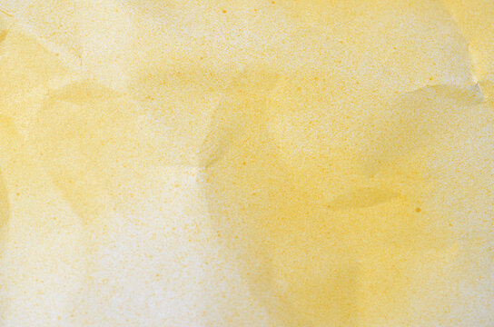 Bright yellow crumpled paper texture with spray paint finish for creative abstract background