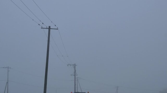 Silhouette of a utility pole in dense fog