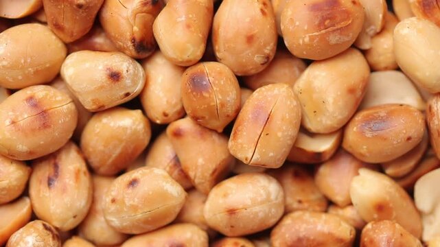 Close-up shot of a pile of roasted peanuts slowly rotating, Top view shot