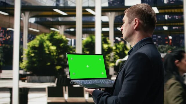 Businessman uses an isolated screen laptop before a work trip; the traveler reviews the journey timetable on the mockup notebook during his daily commute.