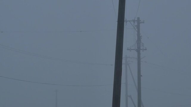 Silhouette of a utility pole in dense fog