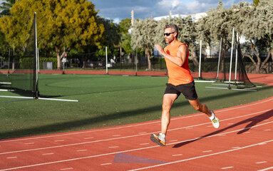 Fototapeta premium Sportsman runner running outdoor. Sport run. Muscular man running. Sportsman jogger running. Man sportsman running to exercise. Sport athlete man run. Runner at long sport run