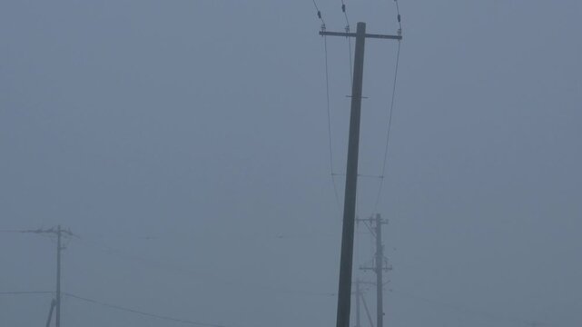 Silhouette of a utility pole in dense fog