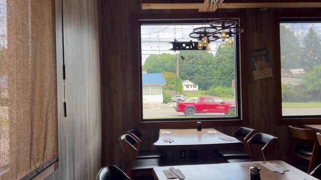 Empty restaurant dining table with large window and street view